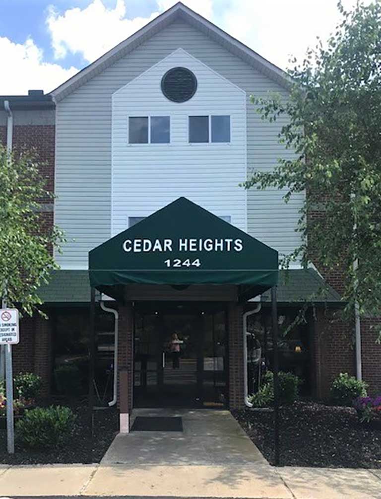 Front entrance of Cedar Heights building with a green awning displaying the name and address 'CEDAR HEIGHTS 1244,' offering affordable housing in the heart of Cedartown, Georgia.