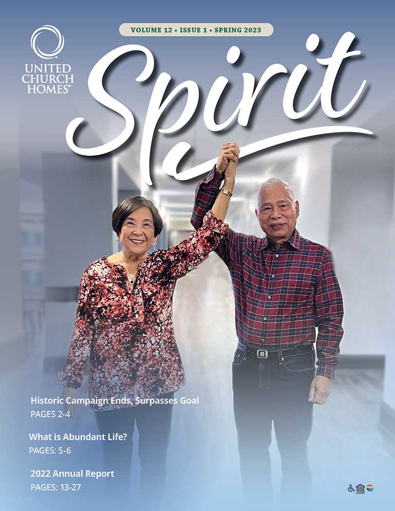 Cover of "Spirit" magazine. Two elderly individuals hold hands while raising their arms, smiling. Magazine heading includes "Volume 12 - Issue 1 - Spring 2023" with articles and report page references, perfect for readers enjoying a senior living blog.