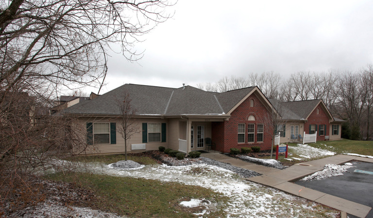 A single-story building with a brick facade and snow-covered grounds on a cloudy winter day, exemplifying the charm of affordable housing in Dayton, Ohio.