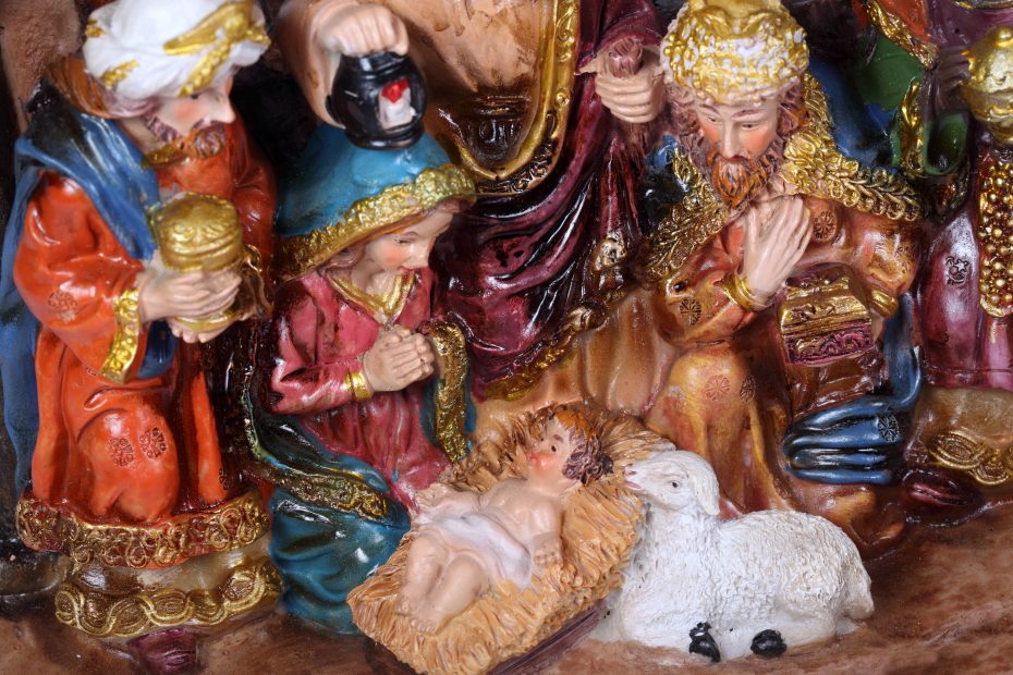 A nativity scene showing three wise men, Mary, baby Jesus, and a lamb, all crafted in colorful, detailed figurines.