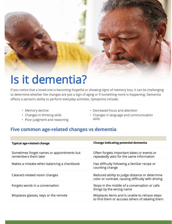 A man looks concerned as a woman next to him reads an aging life guide titled "Is it Dementia?" The guide lists symptoms of dementia and compares age-related changes to dementia indicators.