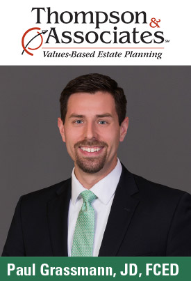 A man in a suit and green tie is smiling against a grey background. Text above reads, "Thompson & Associates Values-Based Estate Planning." Text below reads, "Paul Grassmann, JD, FCED," with expertise in charitable IRA rollover strategies.